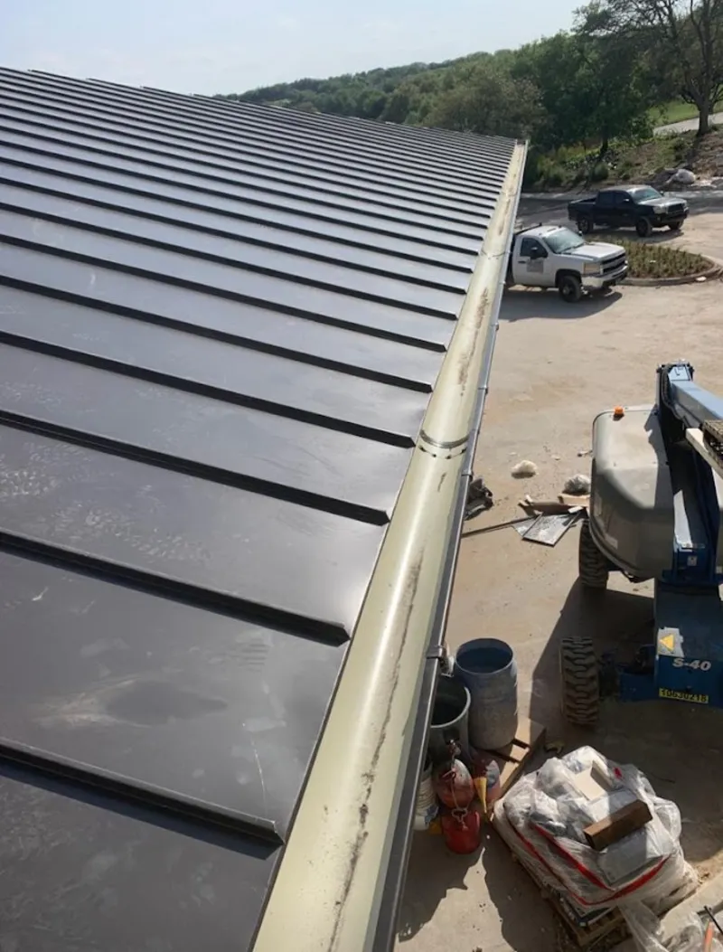 Standing seam panel and gutter detail on a metal roofing jobsite in Belmont